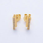 Gold earrings with small diamonds on a light gray background