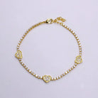 Gold bracelet with heart-shaped charms on a light gray background