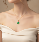 Close-up of a person wearing a necklace with a green pendant
