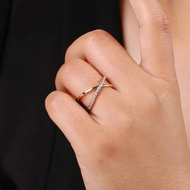 Close-up of a hand wearing a gold Zizi Jewelry ring with a blurred background