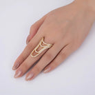 Gold ring with diamonds on a hand against a white background