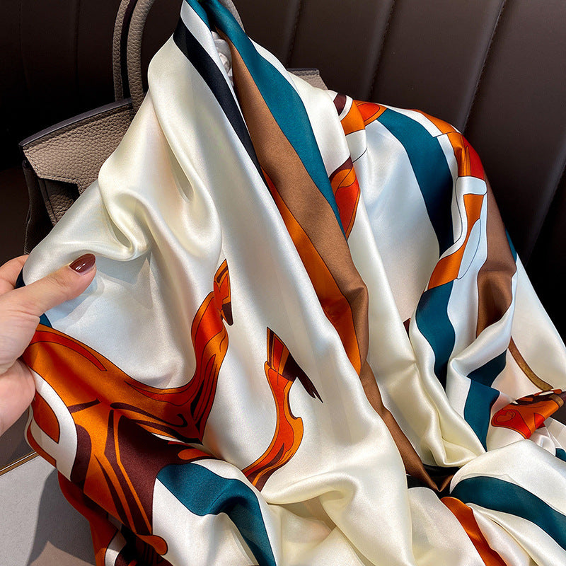Colorful scarf with abstract design held by a hand against a blurred background