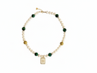 Gold bracelet with green beads on a white background