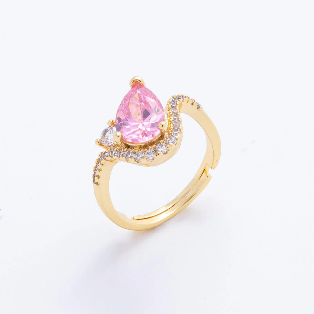 Gold ring with a pink teardrop-shaped gemstone on a white background