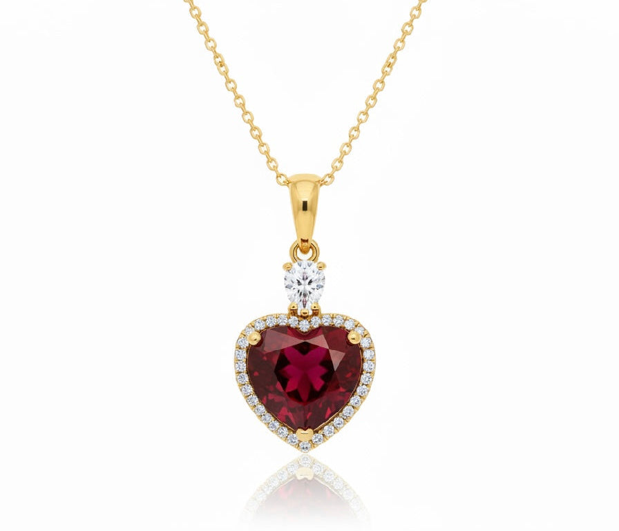 Heart-shaped gemstone pendant with gold chain on a white background