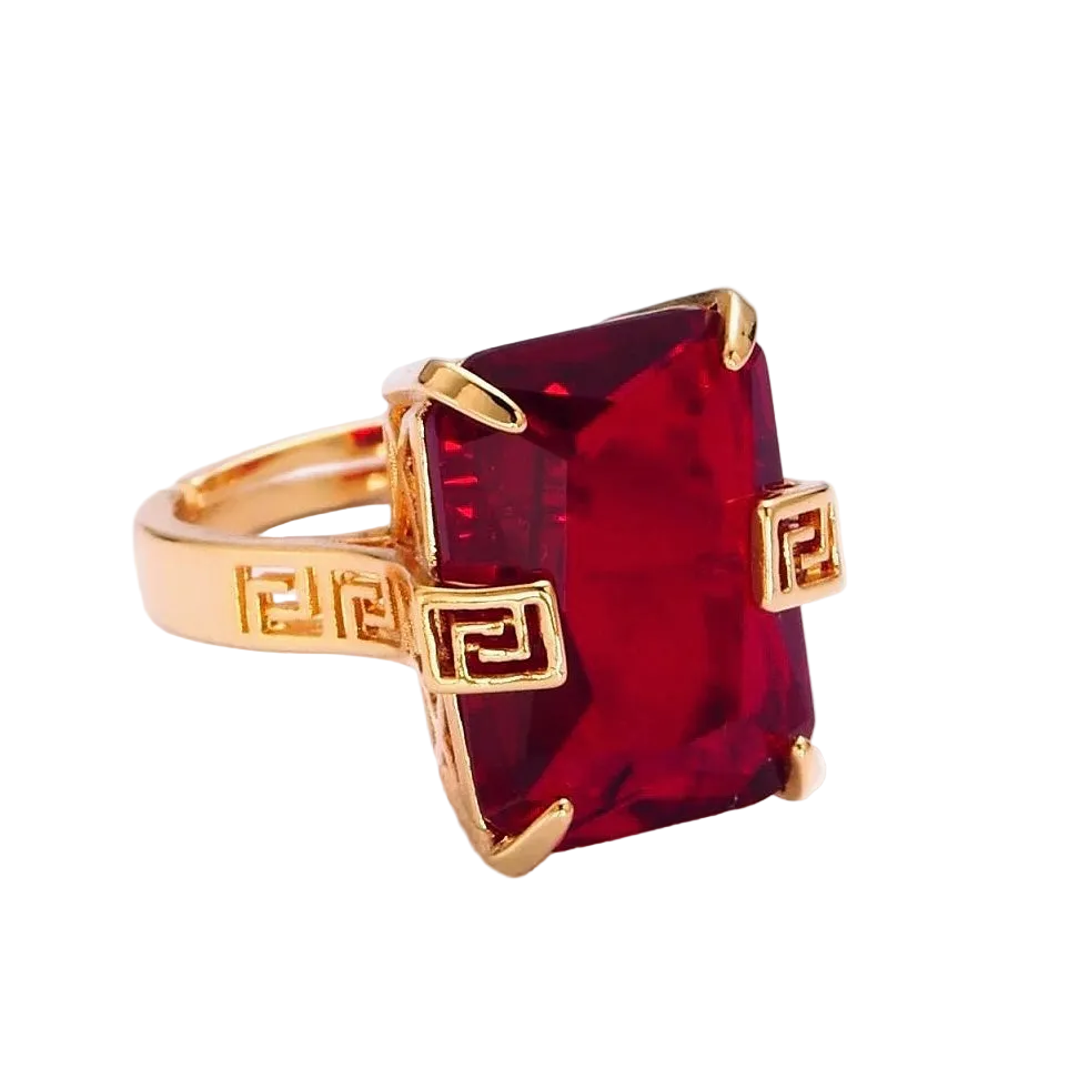 Adjustable gold ring with a large red center stone on a white background