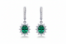 Pair of emerald green gemstone earrings with diamond accents on a white background