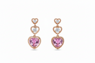 Heart-shaped earrings with pink gemstones and rose gold accents on a white background