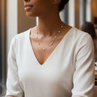Woman wearing a gold chain pearl necklace in a cafe