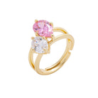 Gold ring with pink and clear gemstones on a white background