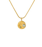 Gold necklace with a round pendant featuring a pearl and gemstone on a white background