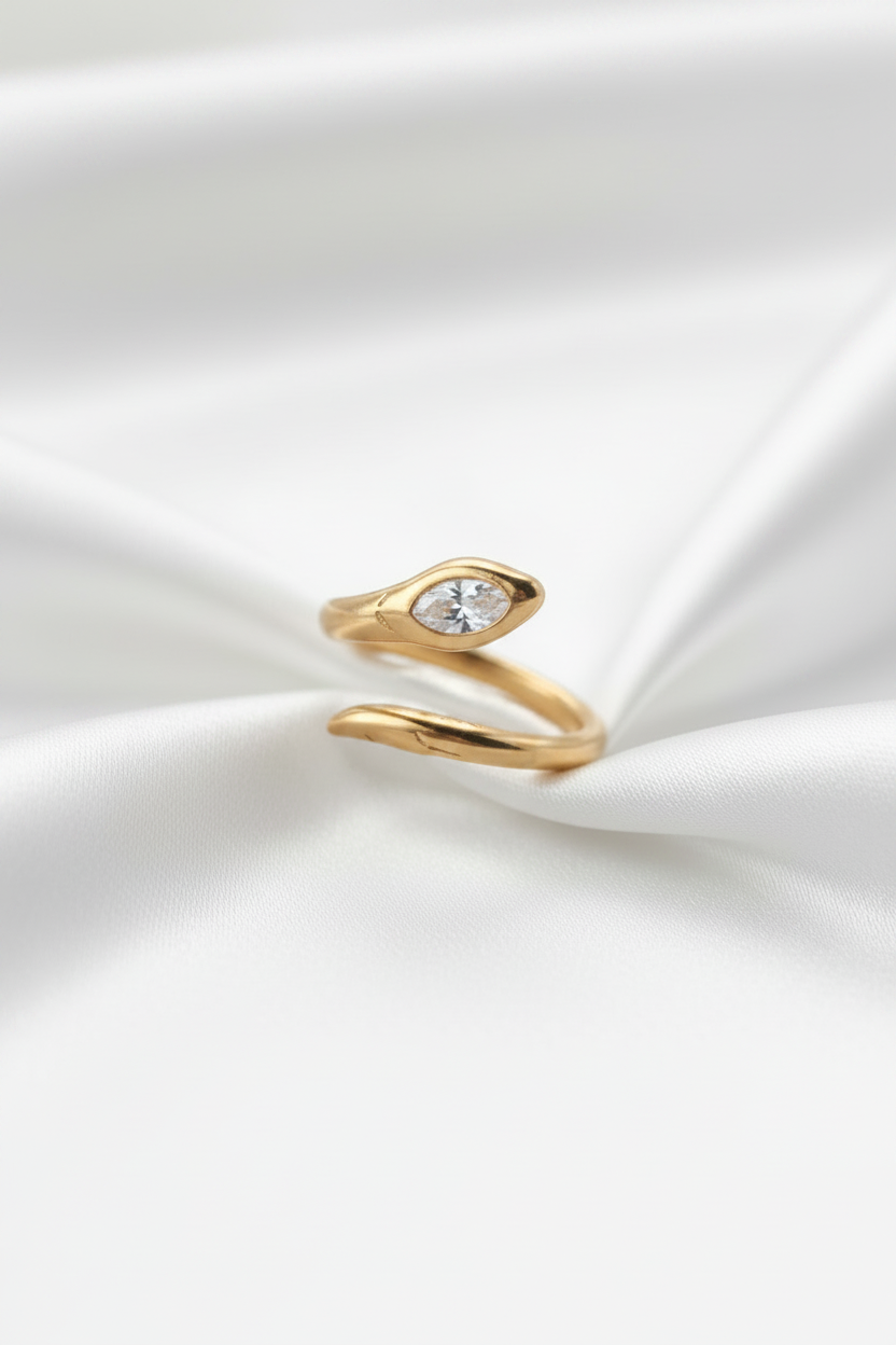 Gold snake-shaped ring on a white background