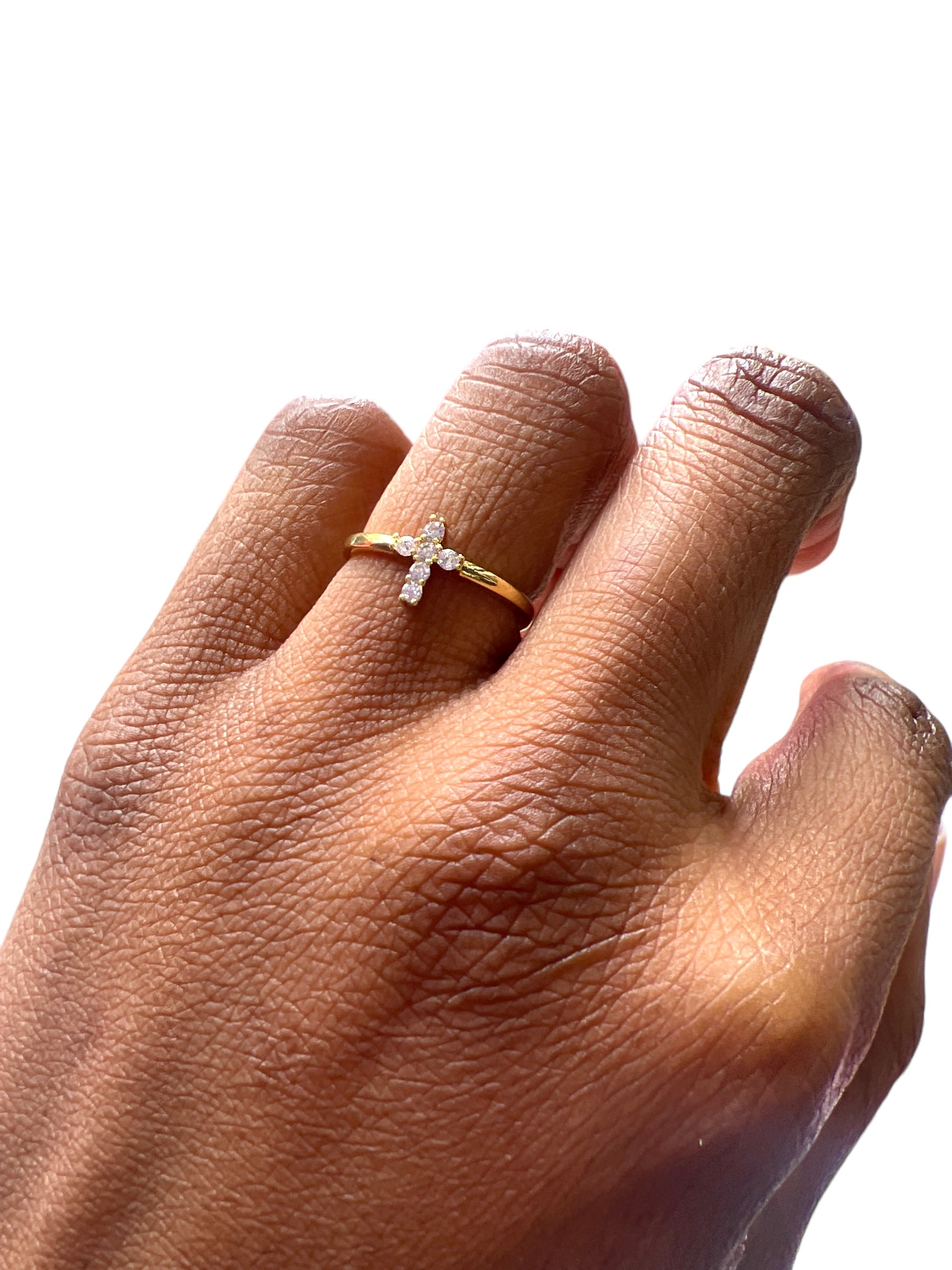 Hand wearing a gold ring with a diamond on a white background