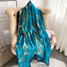 Teal scarf with floral pattern draped over a chair in a room.