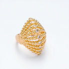 Gold beaded ring with embedded diamonds on a light gray background