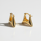 Pair of gold hoop earrings on a light background