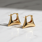 Gold hoop earrings on a light background