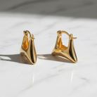 Pair of gold hoop earrings on a light background