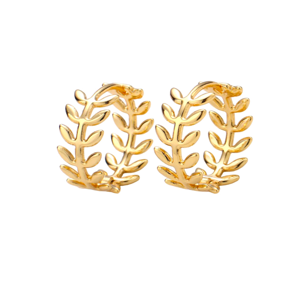 Pair of gold hoop earrings with leaf-like designs on a white background