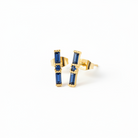Gold earrings with blue gemstones on a white background