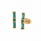 Gold earrings with green gemstones on a white background