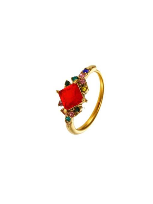 Gold ring with a red gemstone on a white background