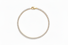 Gold bracelet with clear stones on a white background