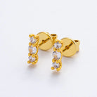 Gold earrings with clear stones on a white background
