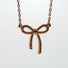 Gold bow-shaped necklace on a white background
