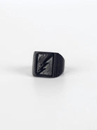 Black ring with a lightning bolt design on a white background