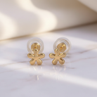 Gold flower-shaped earrings on a white background