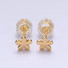 Gold flower-shaped earrings on a light purple background