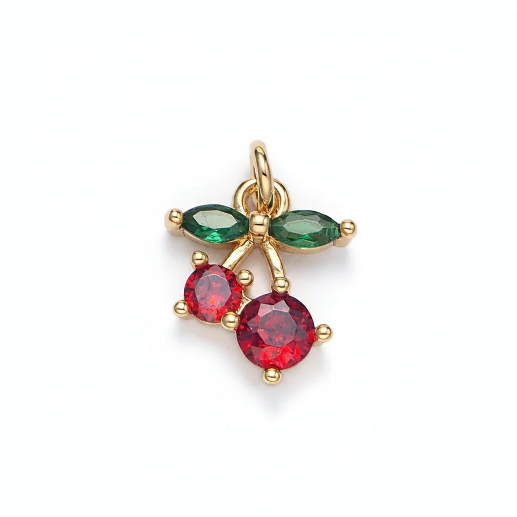 Gold pendant with red and green gemstones on a light gray background