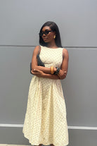 Woman wearing a light-colored dress with a subtle pattern against a gray background