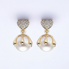 Pair of gold and pearl earrings on a white background