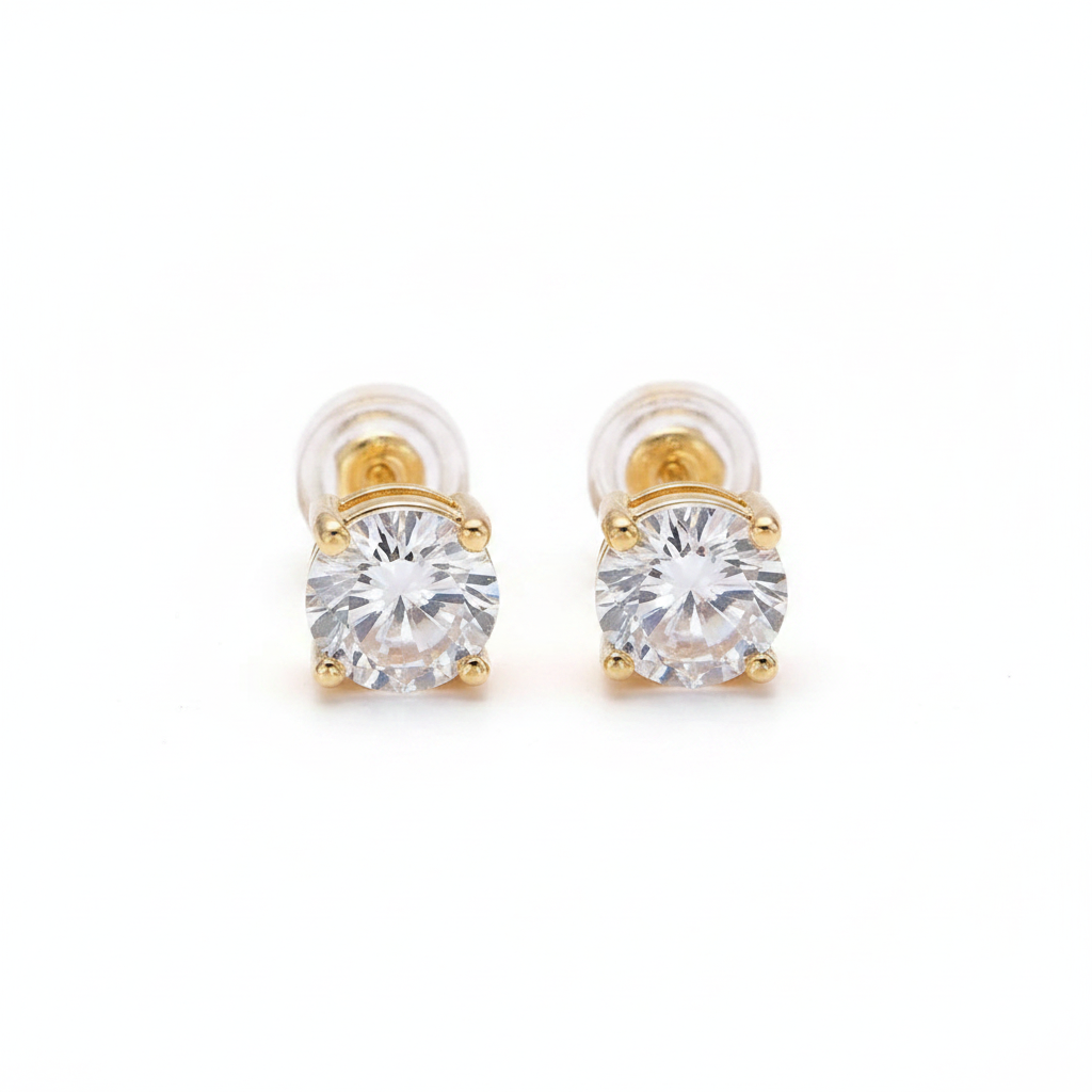 Gold earrings with clear gemstones on a light gray background