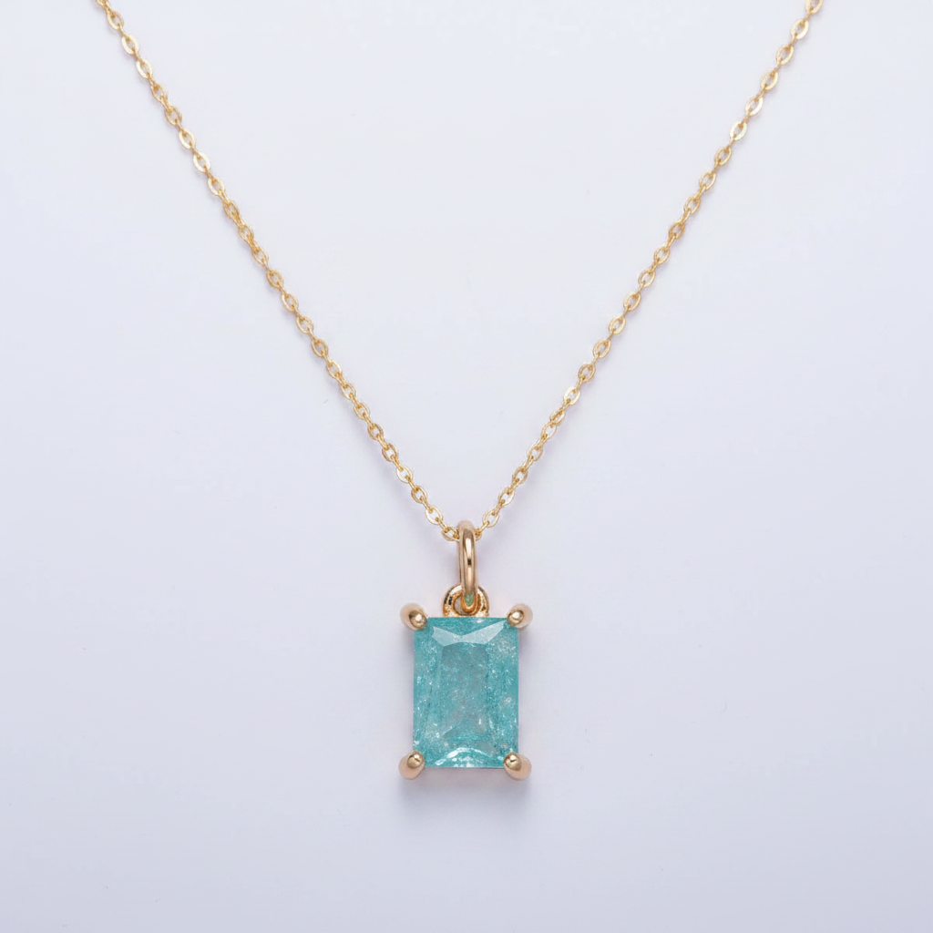 Gold pendant with a rectangular turquoise stone on a light gray background