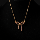 Gold bow-shaped necklace on a black background
