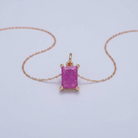 Pink gemstone pendant on a gold chain against a light gray background