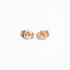 Pair of gold earrings with embedded diamonds on a white background