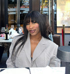 Woman sitting at a table in an outdoor restaurant setting