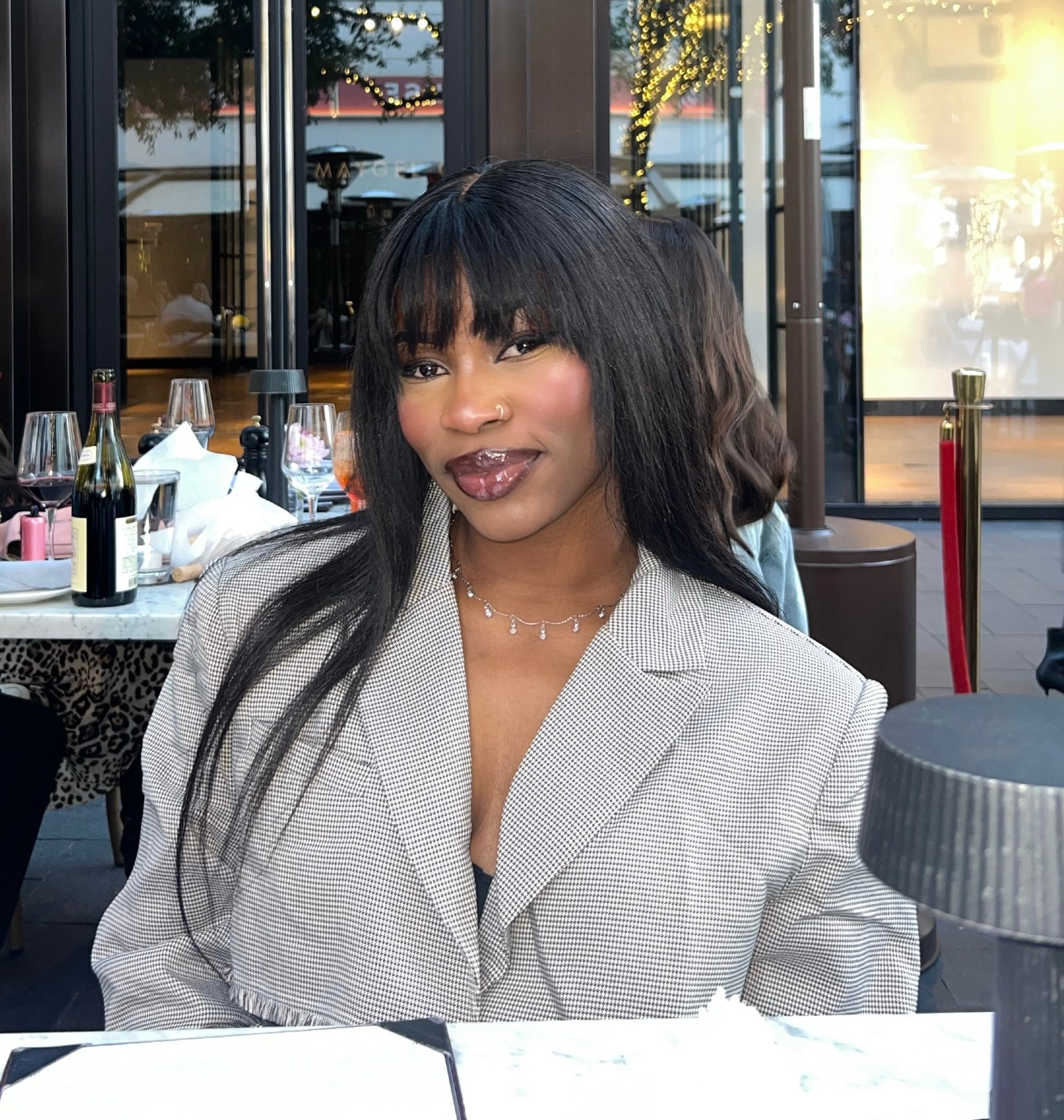 Woman sitting at a table in an outdoor restaurant setting