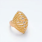 Gold beaded ring with embedded diamonds on a light gray background
