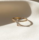 Gold cross ring with diamonds on a white background