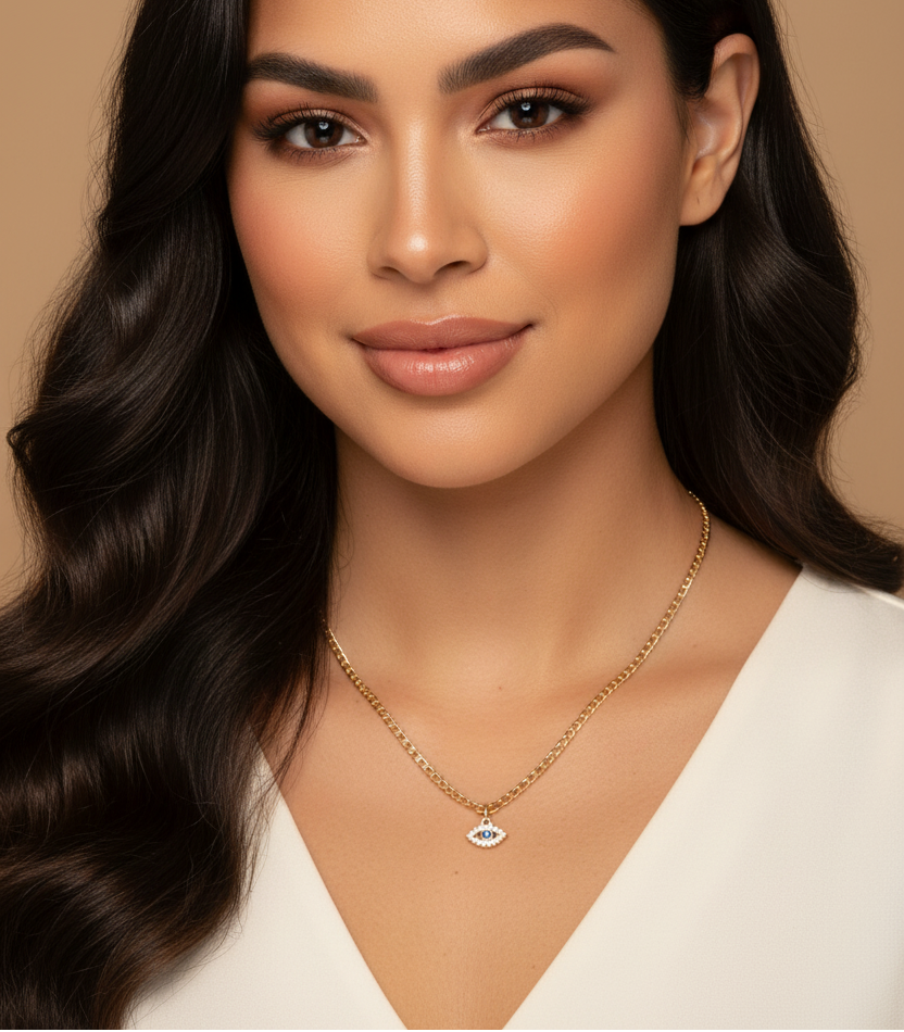 Woman with long wavy hair wearing a gold necklace on a beige background