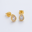 Gold earrings with teardrop-shaped gemstones on a light gray background