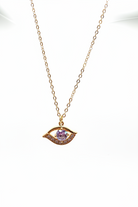 Gold necklace with an eye-shaped pendant on a white background