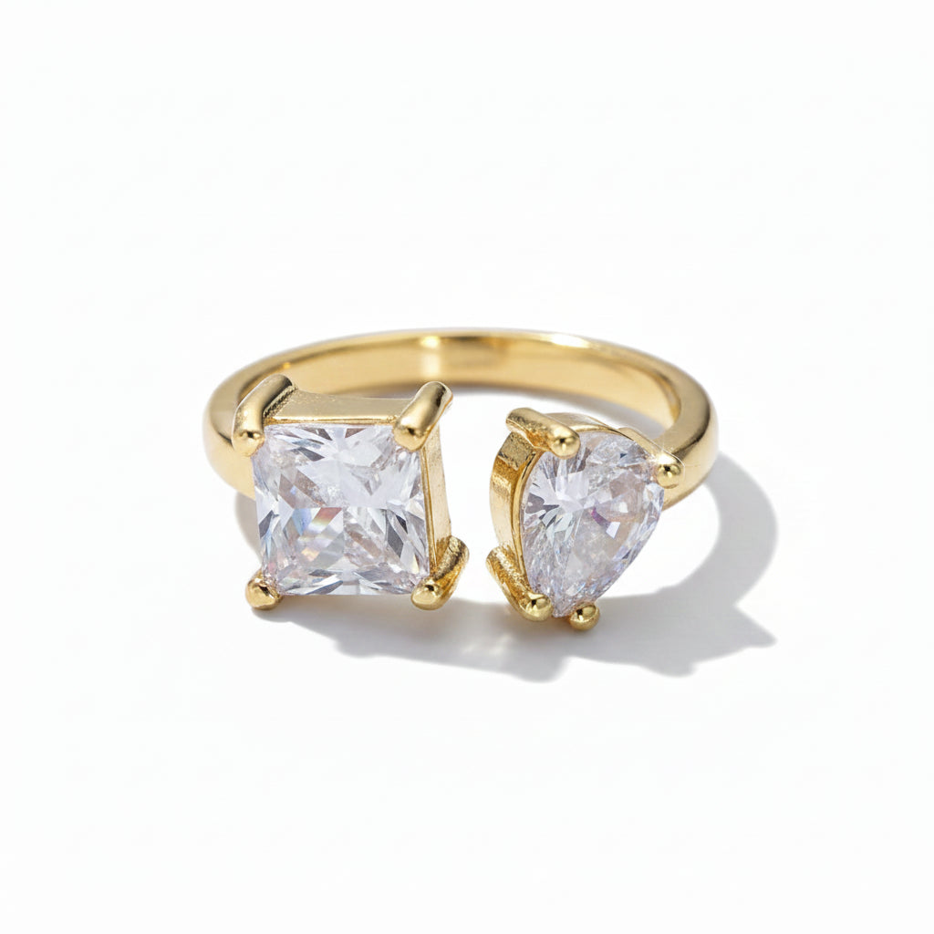 Gold ring with two clear gemstones on a white background
