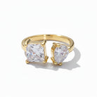 Gold ring with two clear gemstones on a white background