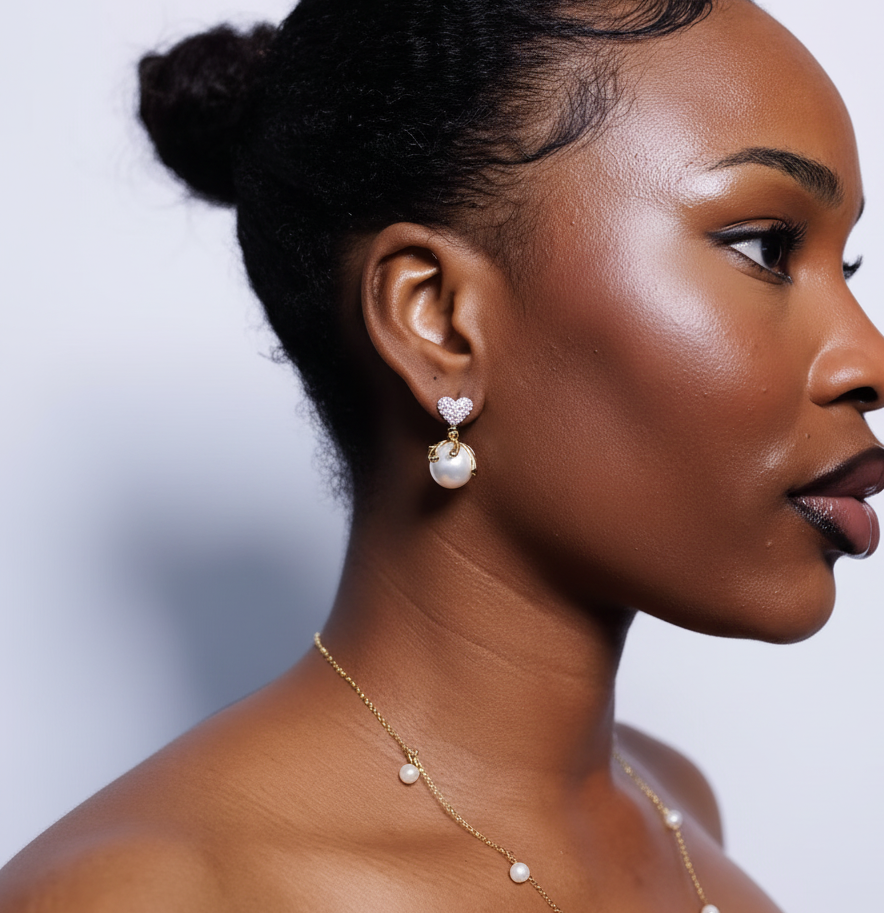 Woman wearing pearl earrings and necklace against a plain background